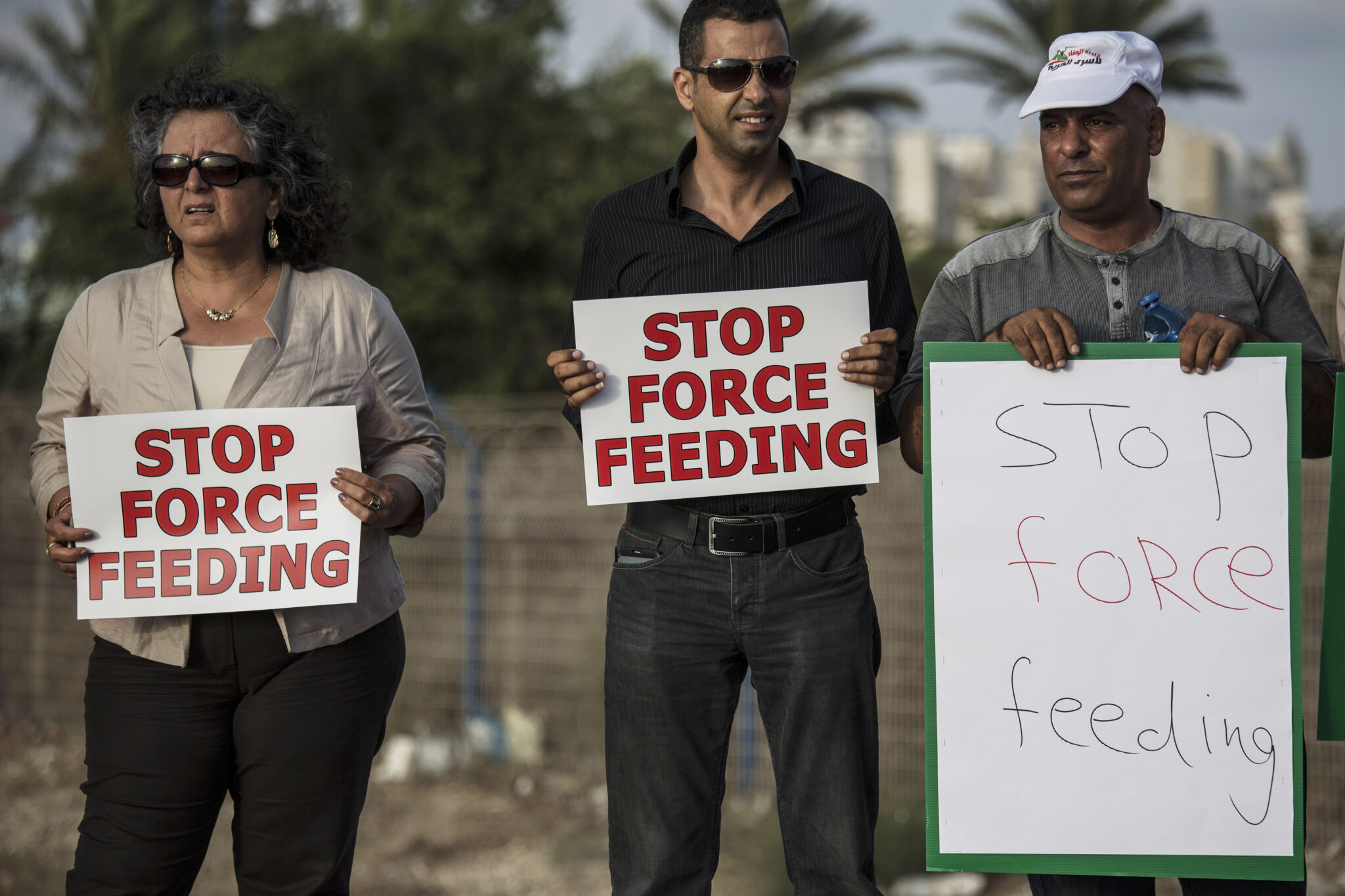 In this photo made on Tuesday, August 11, 2015, Israeli Arab supporters of Mohammed Allan, a Palestinian prisoner on a hunger strike, hold signs during a support rally outside Barzilai hospital, in the costal city of Ashkelon Israel. Israel passed a law to force feed hunger strikers by a slim margin in July and elicited harsh criticism. Critics call force-feeding an unethical violation of patient autonomy and akin to torture. The Israeli Medical Association, which has urged physicians not to cooperate, is challenging the law in the Supreme Court. (AP Photo/Tsafrir Abayov)