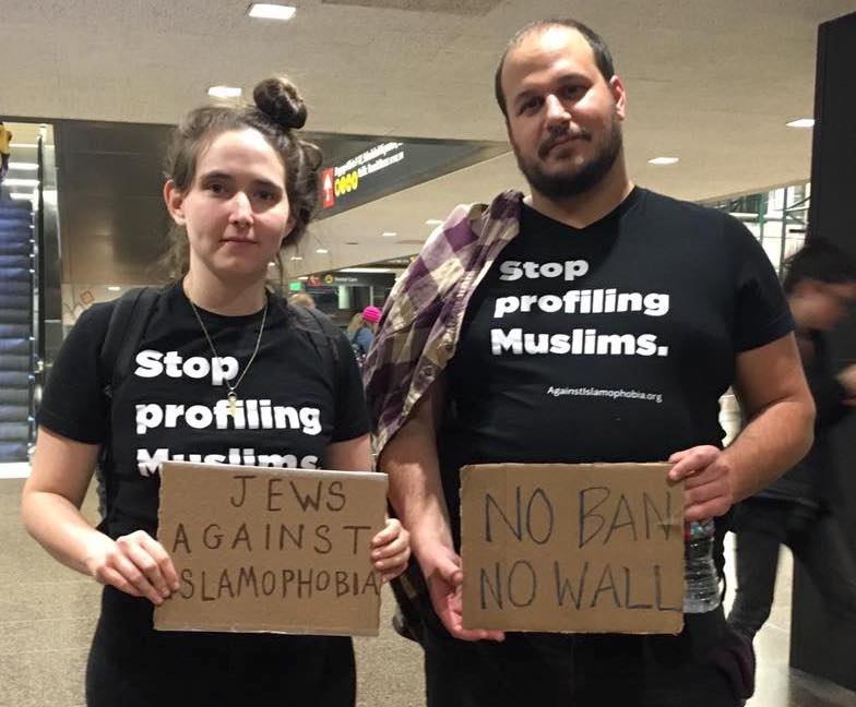 Two JVP members in SeaTac wearing shirts that read "Stop Profiling Muslims".