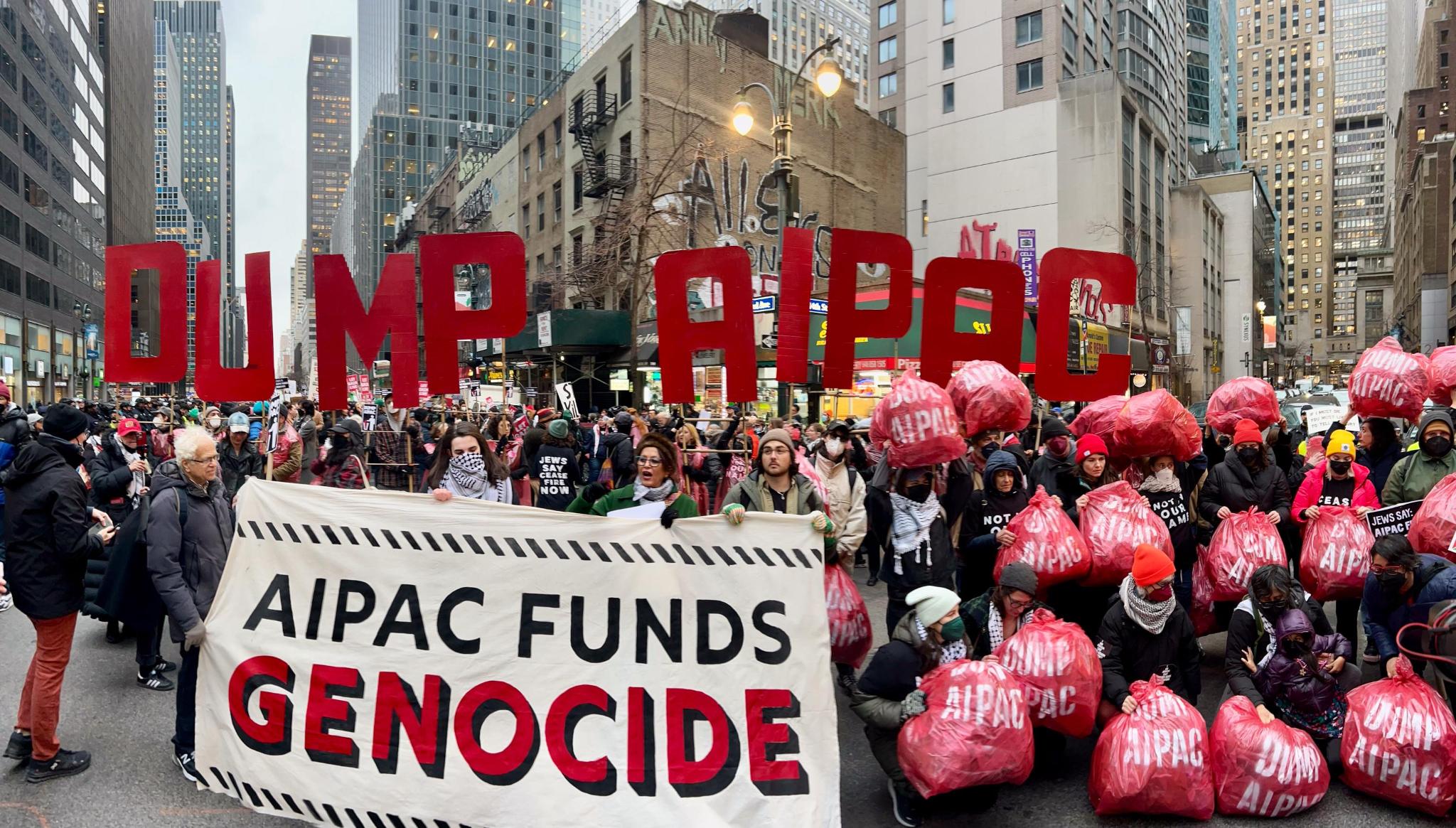 A group of people hold up a sign reading "AIPAC FUNDS GENOCIDE."