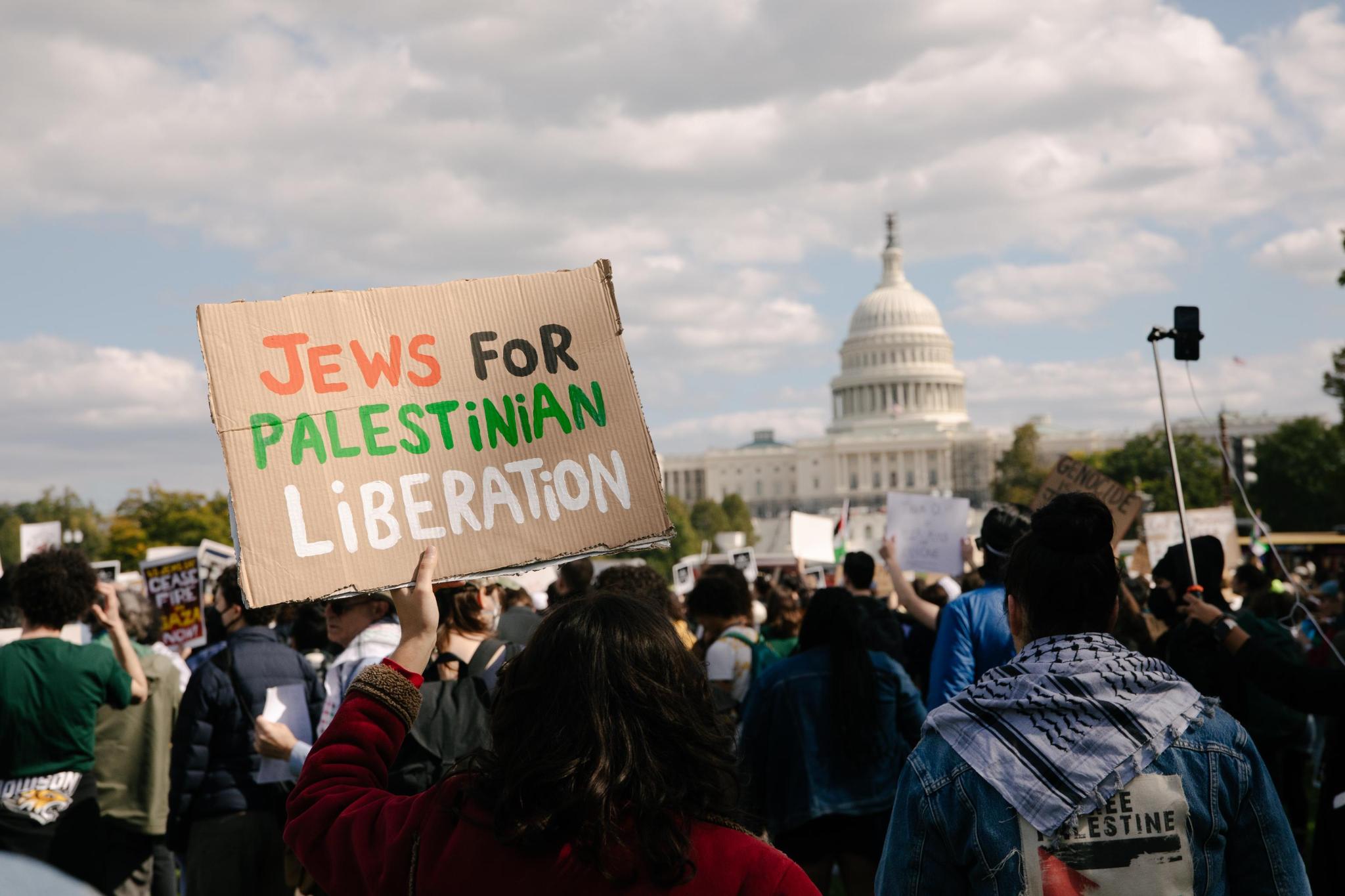 A person holds a sign reading "Jews for Palestinian Liberation"