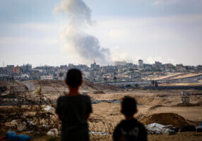 TOPSHOT - Boys watch smoke billowing during Israeli strikes east of Rafah in the southern Gaza Strip on May 13, 2024, amid the ongoing conflict between Israel and the Palestinian militant group Hamas. (Photo by AFP) (Photo by -/AFP via Getty Images)